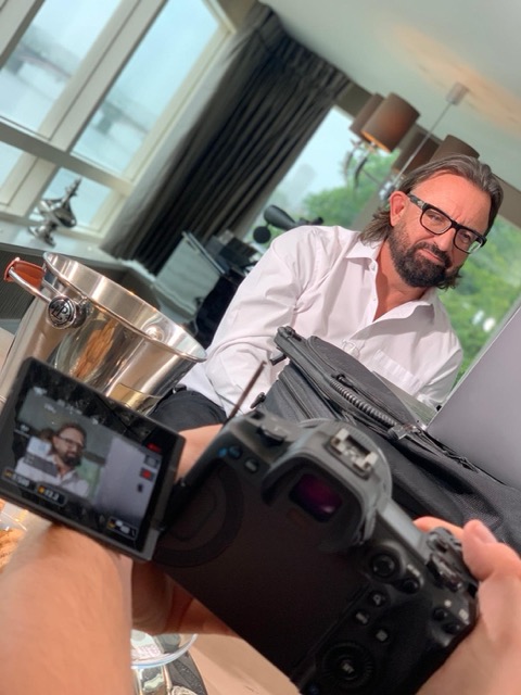 Terry Fisher being filmed for an interview, camera screen in the foreground