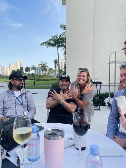 Terry Fisher at an outdoor table with Grant Cardone and other attendees at 10X